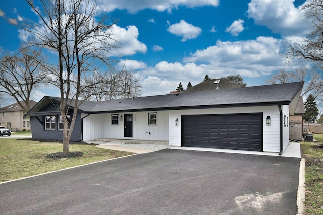 single story home featuring a garage, fence, a front lawn, and driveway