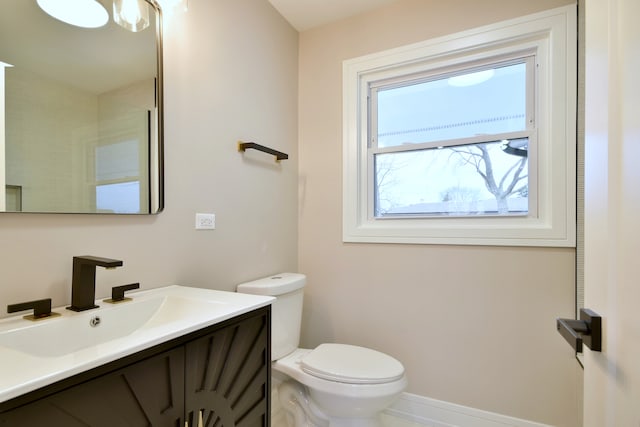 bathroom featuring baseboards, toilet, and vanity