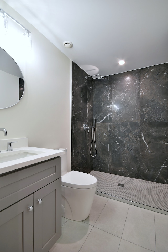 bathroom with toilet, tile patterned floors, a marble finish shower, and vanity