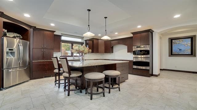 kitchen featuring recessed lighting, dark brown cabinets, a kitchen island, and stainless steel appliances