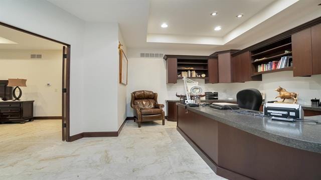 office space with recessed lighting, visible vents, baseboards, and a tray ceiling