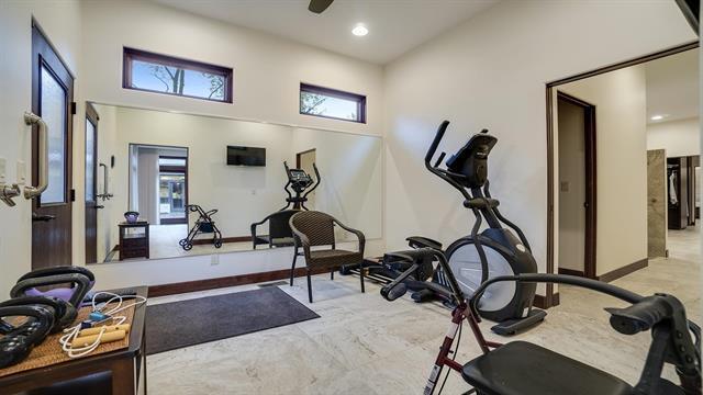workout room featuring baseboards, a towering ceiling, and recessed lighting