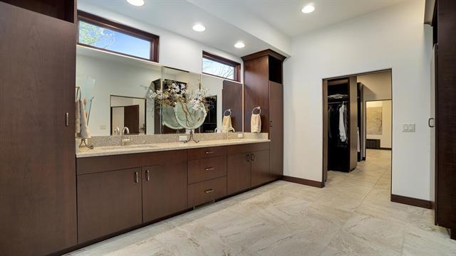 bathroom with baseboards, a sink, double vanity, and recessed lighting