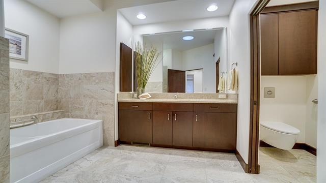 bathroom featuring recessed lighting, a garden tub, toilet, and vanity