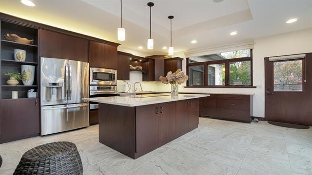 kitchen featuring stainless steel appliances, dark brown cabinetry, recessed lighting, a raised ceiling, and hanging light fixtures