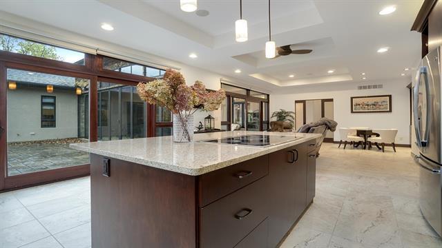 kitchen featuring open floor plan, black electric stovetop, dark brown cabinetry, a raised ceiling, and freestanding refrigerator