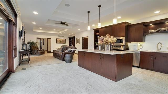 kitchen with open shelves, stainless steel appliances, light countertops, and a sink