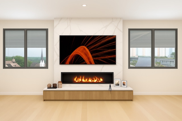 detailed view of a high end fireplace, baseboards, wood finished floors, and recessed lighting