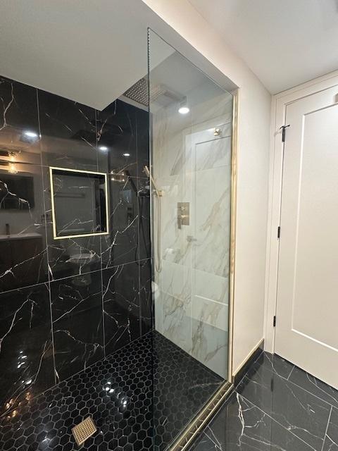bathroom featuring marble finish floor and a marble finish shower