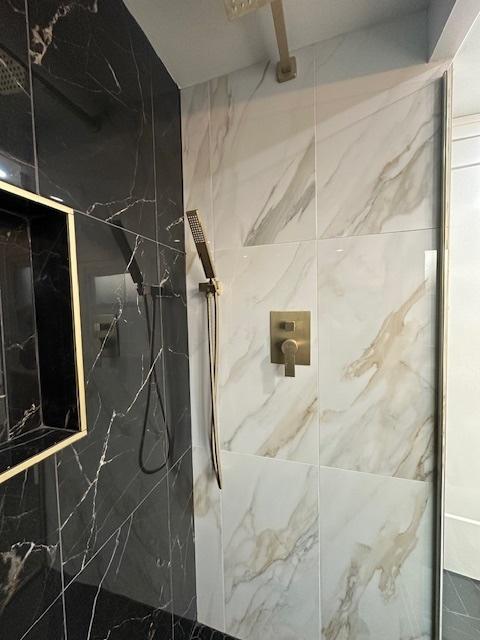 room details featuring a marble finish shower