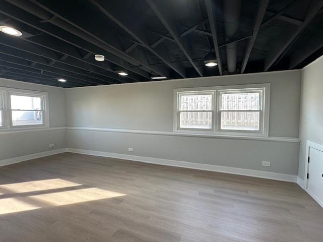 basement featuring baseboards and wood finished floors