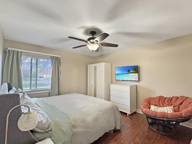 bedroom with baseboards, a ceiling fan, and dark wood-style flooring