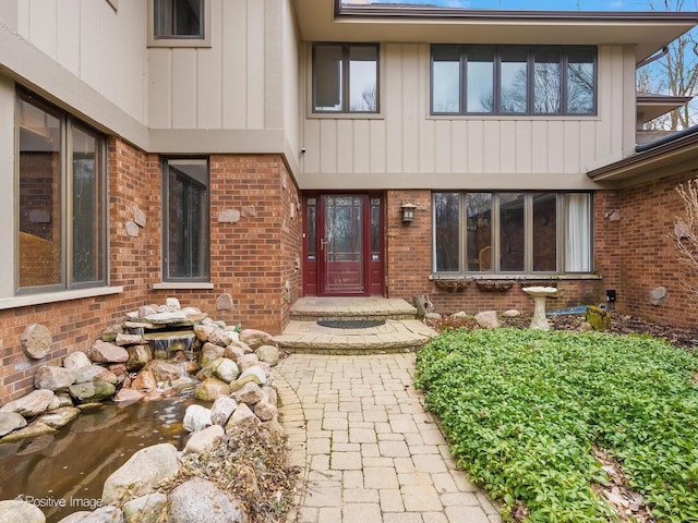 entrance to property featuring brick siding