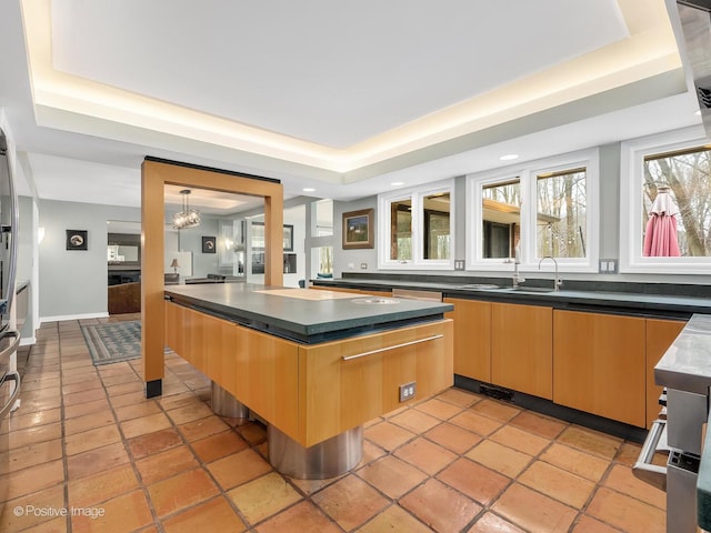 bar featuring recessed lighting, a notable chandelier, a tray ceiling, and a sink
