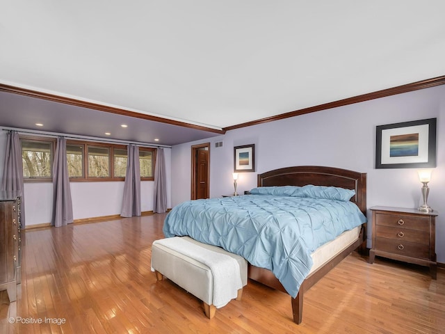 bedroom featuring baseboards, crown molding, visible vents, and light wood-type flooring