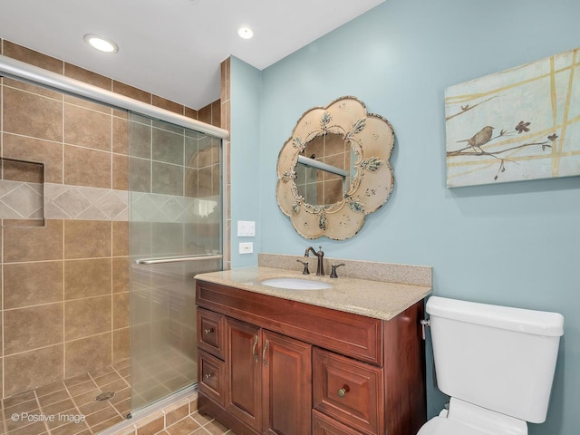 bathroom featuring recessed lighting, toilet, vanity, and a stall shower