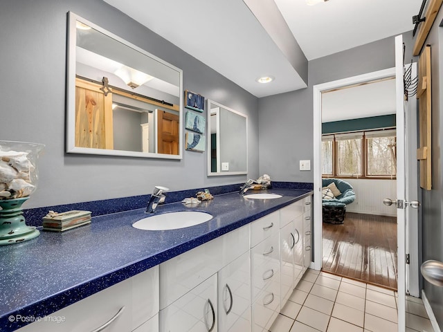 bathroom featuring tile patterned flooring, a sink, double vanity, and ensuite bathroom