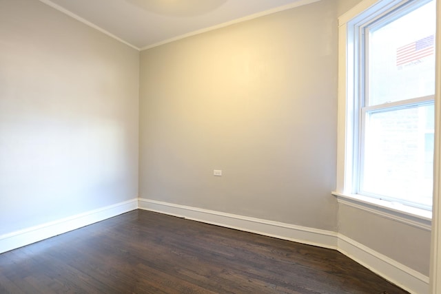 empty room with crown molding, baseboards, and dark wood-style flooring