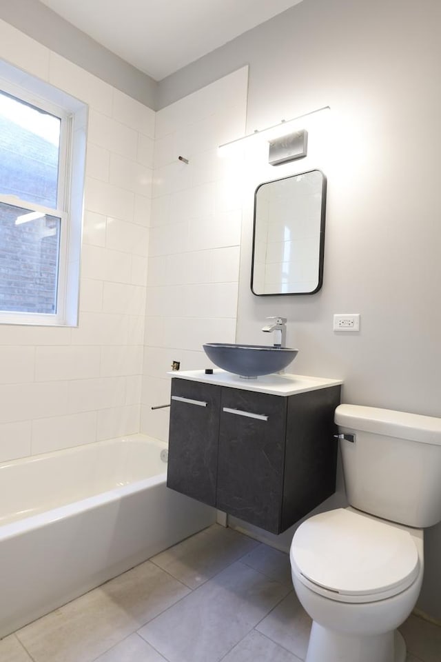 bathroom featuring tile patterned flooring, toilet, vanity, and  shower combination