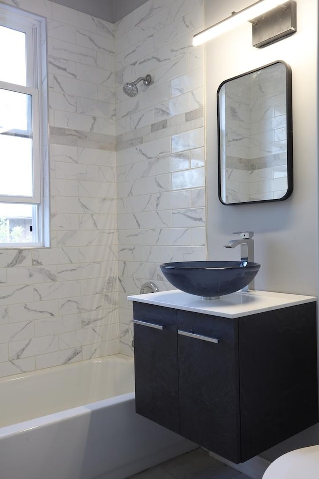 bathroom featuring toilet, vanity, shower / tub combination, and plenty of natural light