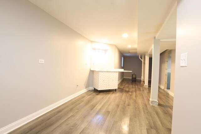 hall with baseboards, wood finished floors, and recessed lighting