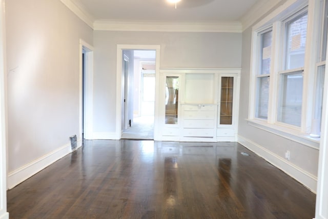 unfurnished room featuring wood finished floors, crown molding, and baseboards