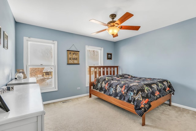 bedroom featuring baseboards, visible vents, light colored carpet, and multiple windows
