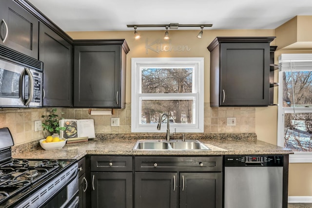 kitchen with a wealth of natural light, a sink, appliances with stainless steel finishes, and tasteful backsplash
