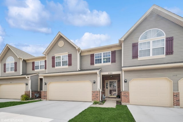 multi unit property featuring brick siding, a garage, and driveway