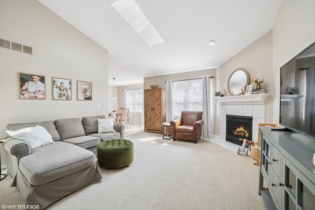 living area with a skylight, light carpet, a fireplace, and visible vents