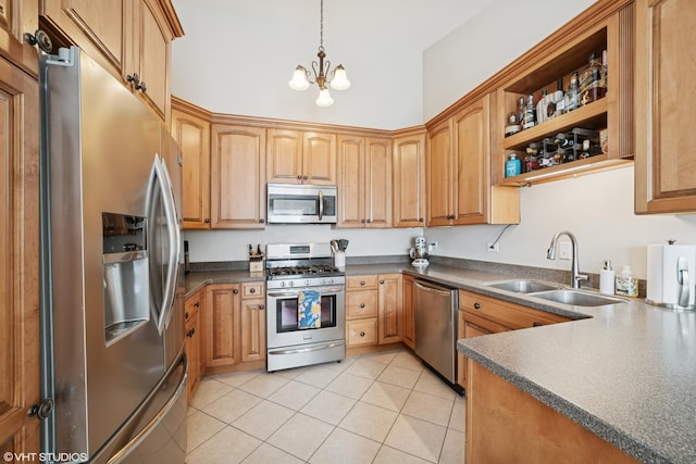 kitchen with light tile patterned flooring, dark countertops, a sink, appliances with stainless steel finishes, and a notable chandelier
