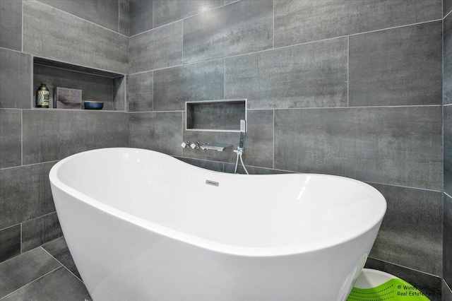 full bathroom featuring a soaking tub and tile walls
