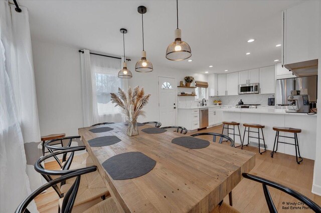 dining room with recessed lighting and light wood-style flooring