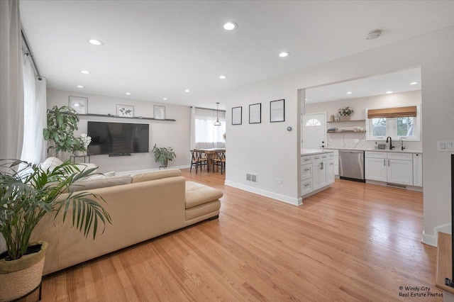 living area with plenty of natural light, visible vents, light wood finished floors, and recessed lighting