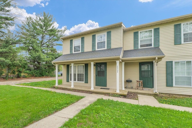multi unit property with covered porch and a front yard
