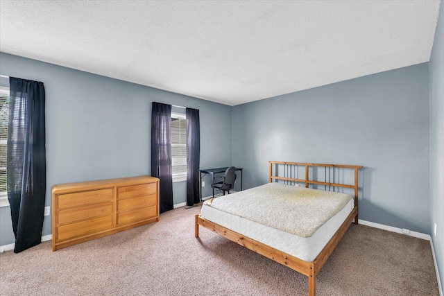 bedroom featuring a textured ceiling, multiple windows, and light colored carpet