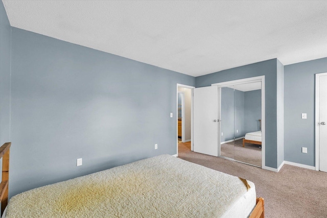 carpeted bedroom with a closet and baseboards