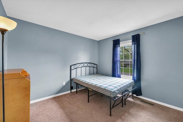 carpeted bedroom featuring visible vents and baseboards