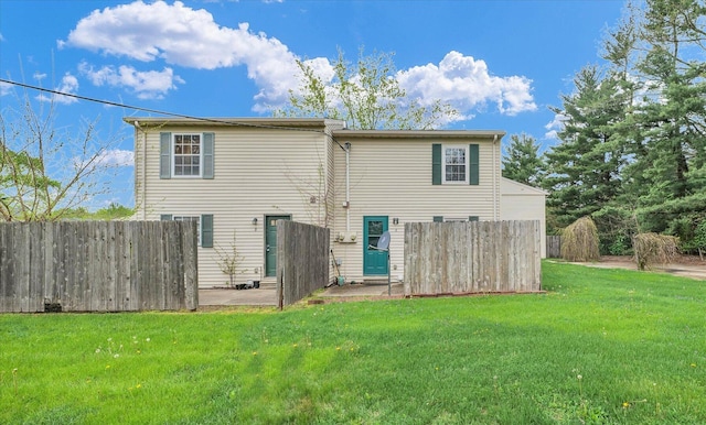 rear view of property featuring fence, a lawn, and a patio area
