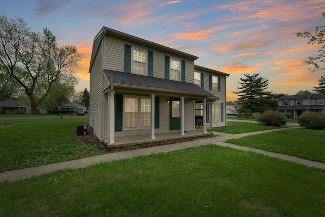 view of front of home with a porch, cooling unit, and a front lawn