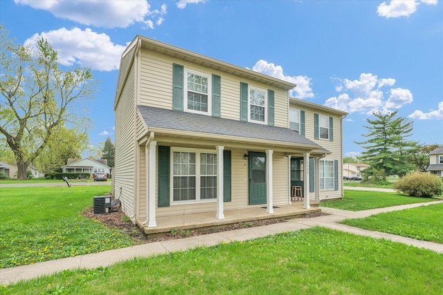 traditional-style home with a porch, a front yard, and central AC unit