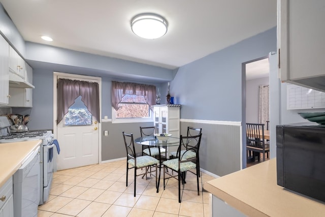 2532 Lee St, Woodridge, IL 60517 - kitchen featuring light tile patterned flooring, white appliances, a wainscoted wall, light countertops, and under cabinet range hood