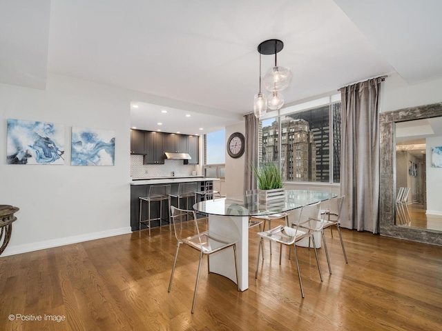 dining space with baseboards and dark wood-style flooring