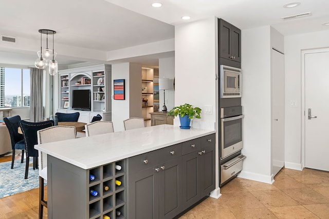 kitchen with a breakfast bar, visible vents, a warming drawer, a peninsula, and appliances with stainless steel finishes