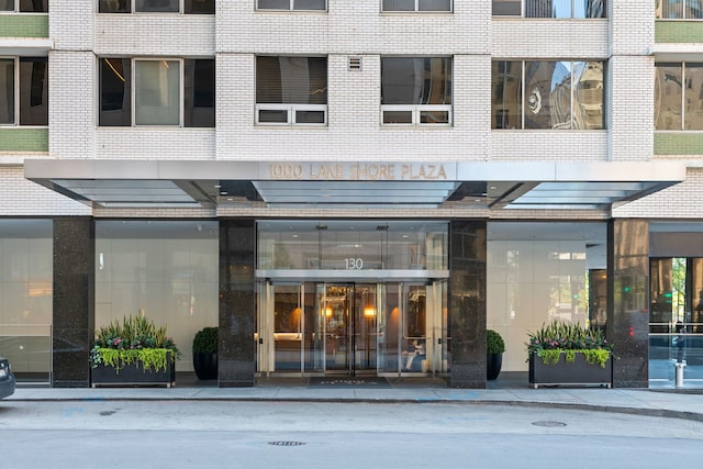 view of exterior entry featuring brick siding