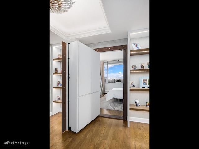 hall with wood finished floors and crown molding