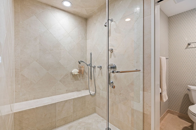 full bathroom with a tile shower and toilet