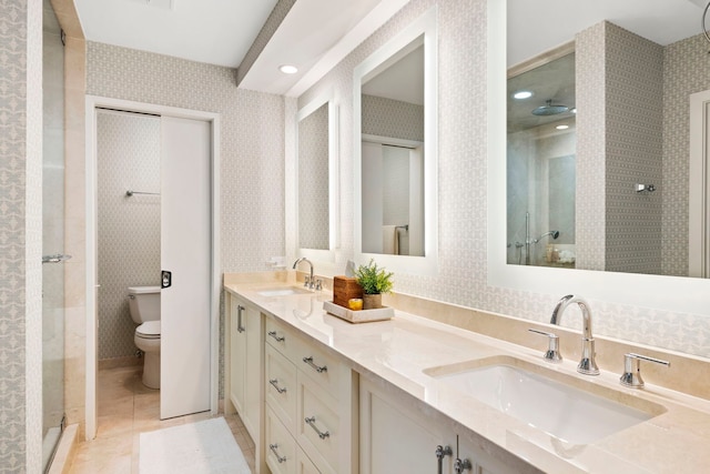 full bath featuring a sink, a shower stall, double vanity, and toilet