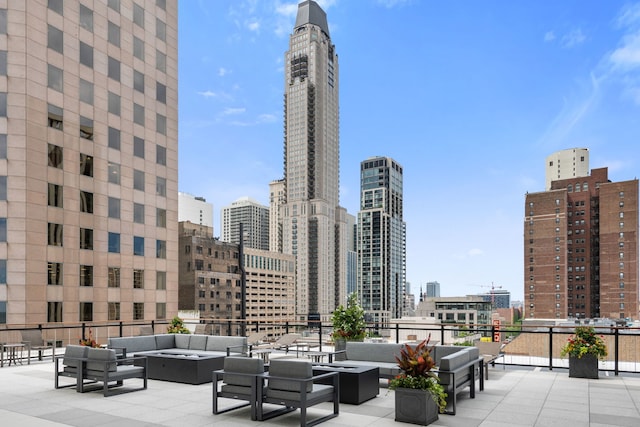 view of patio / terrace featuring an outdoor living space with a fire pit and a view of city