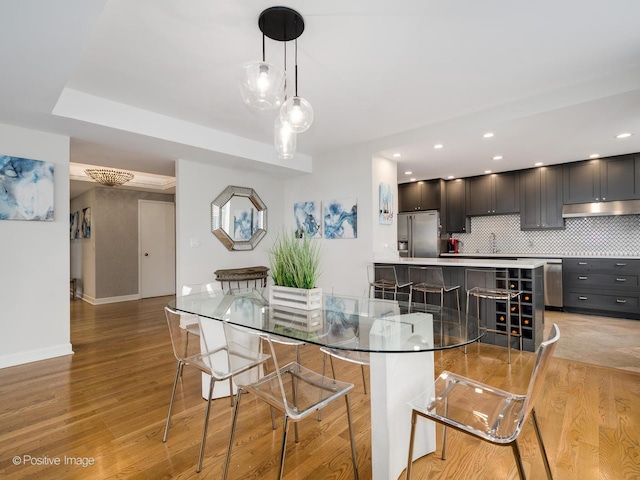 dining space with light wood-style flooring, baseboards, and recessed lighting